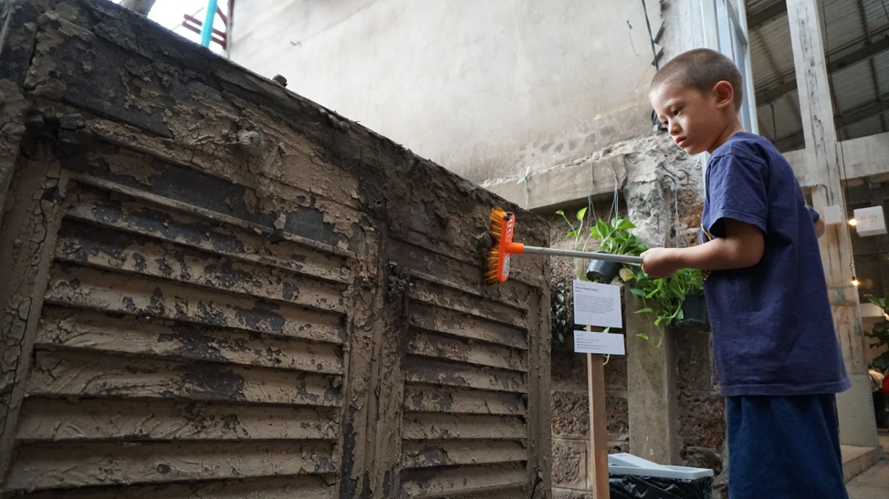 Art installation by participant-artist Al Lim. Visitors were invited to clean a cabinet covered in silt and mud from the local river, simulating the cleanup that flood victims employ after their belongings are inundated with flood water. This installation was part of the Living With Water art exhibition (Source: Rachel Siao/Earth Observatory of Singapore)